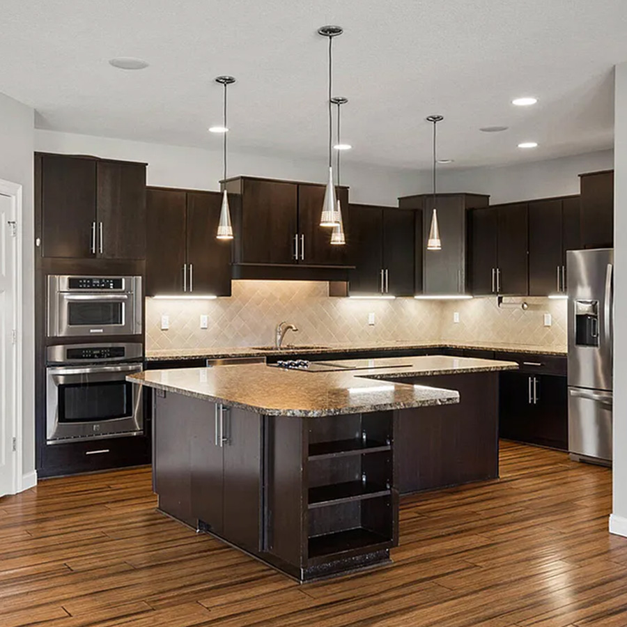 Kitchen with dark wood cabinets, granite counters and tan tile backsplash