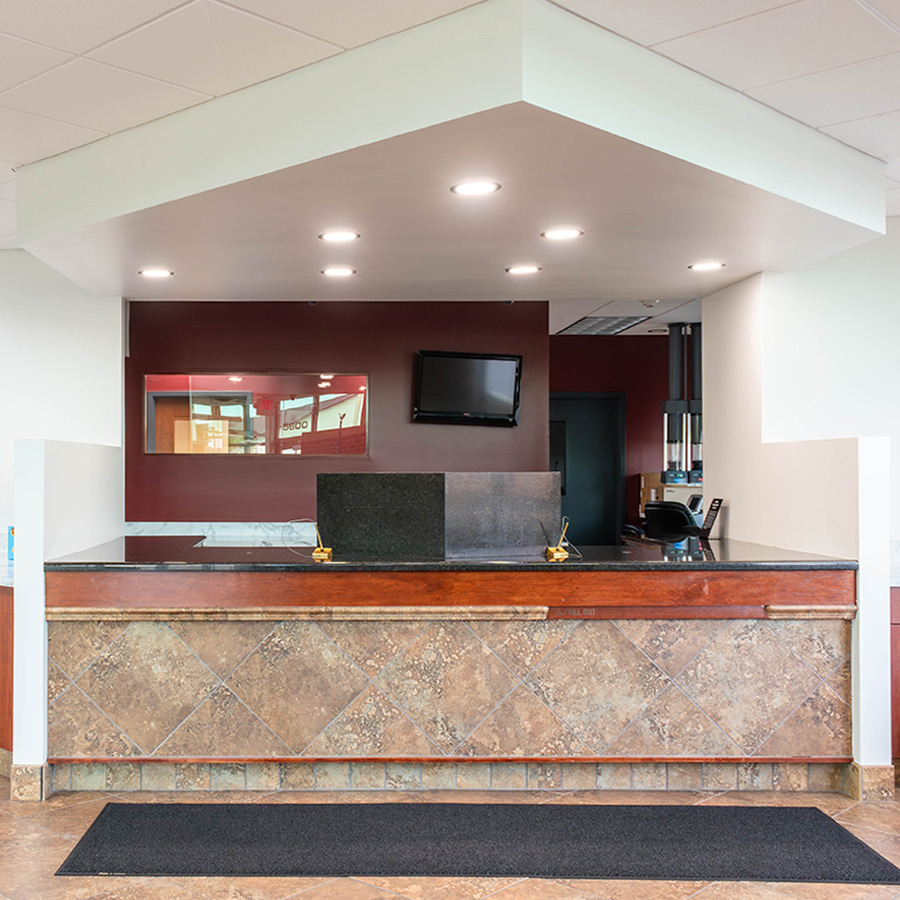 Updated bank teller line with white soffit, bright lighting and a deep red accent wall
