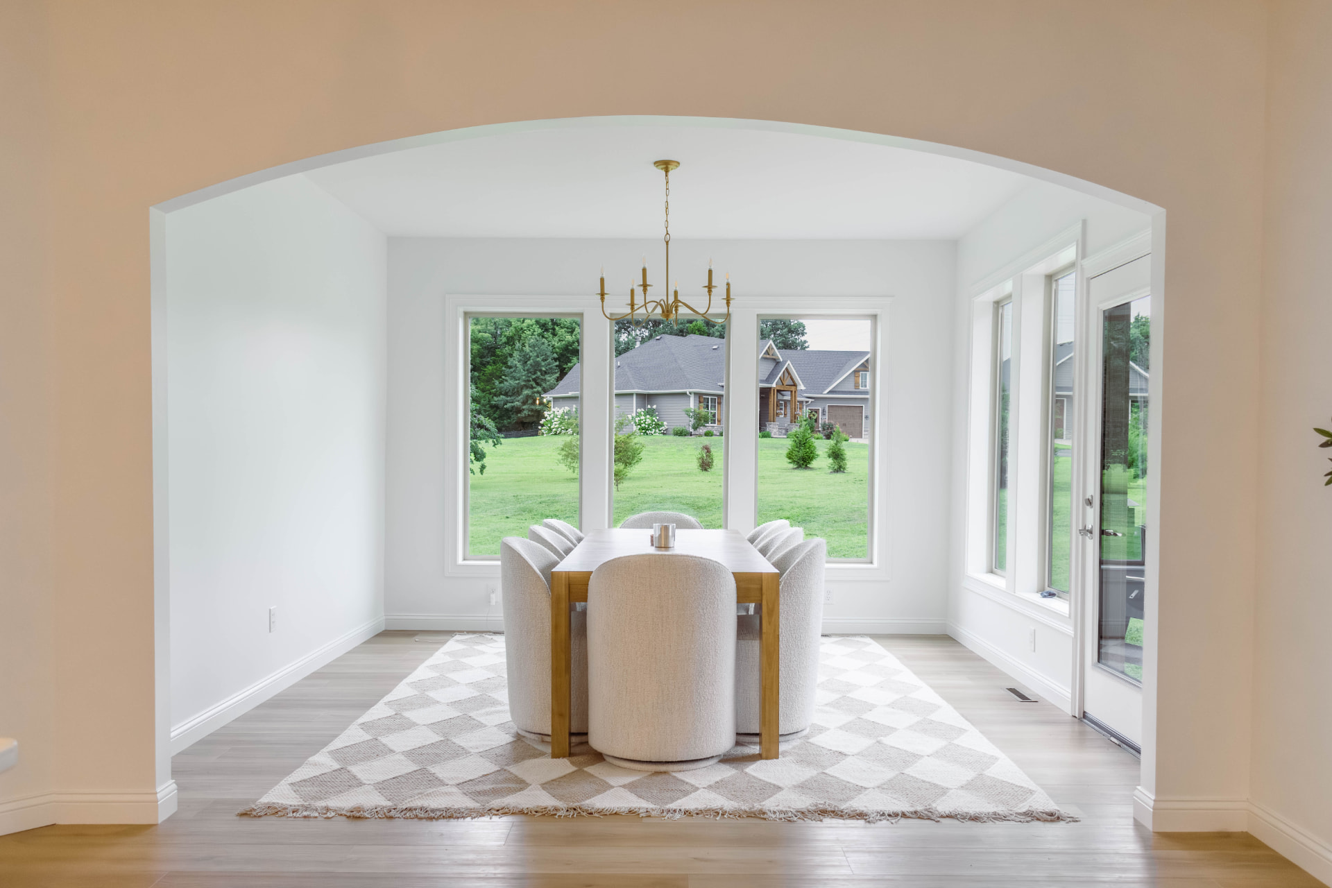 Renovated dining room with a brass chandelier and large windows