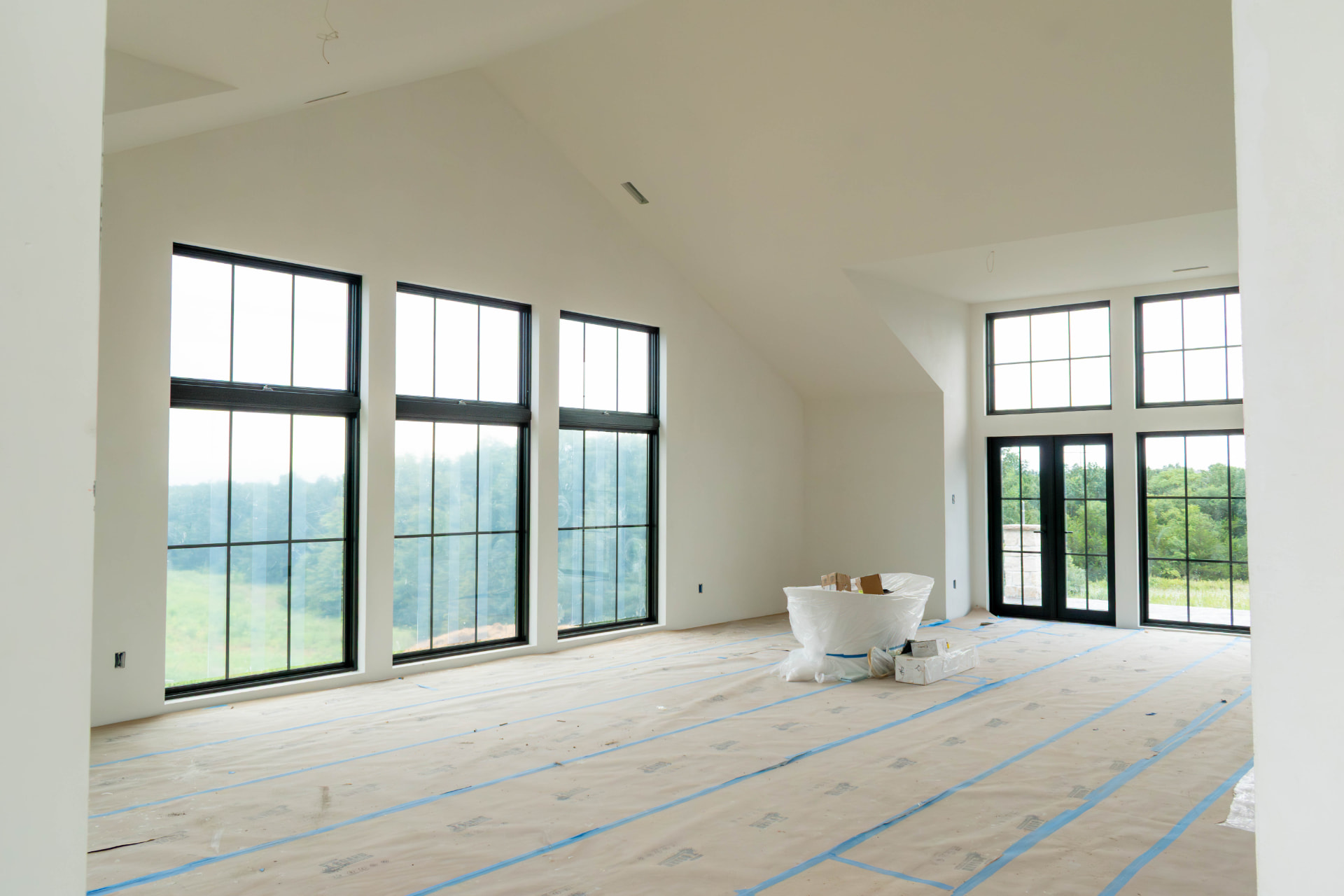 Vaulted great room with tall black-framed windows in a Nashville-area remodel