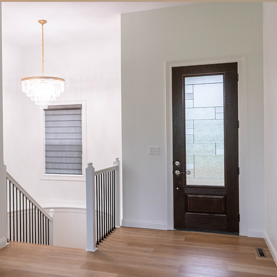 Entry landing with white painted railing, black balusters and a crystal chandelier