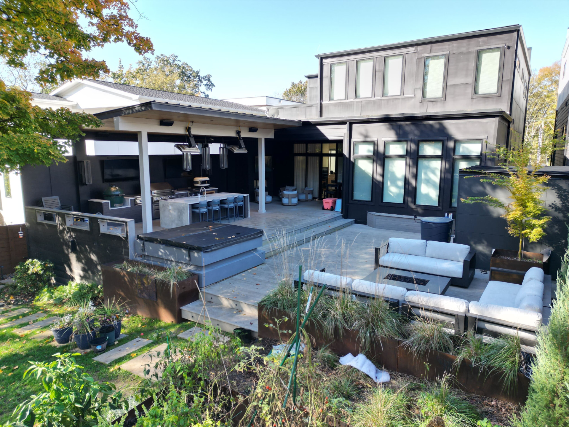 Covered outdoor kitchen and multi-level deck with hot tub and fire-pit lounge